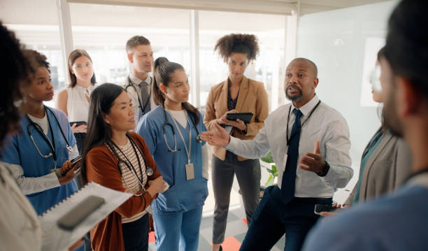 Healthcare leader meeting with clinical team members in a hospital corridor